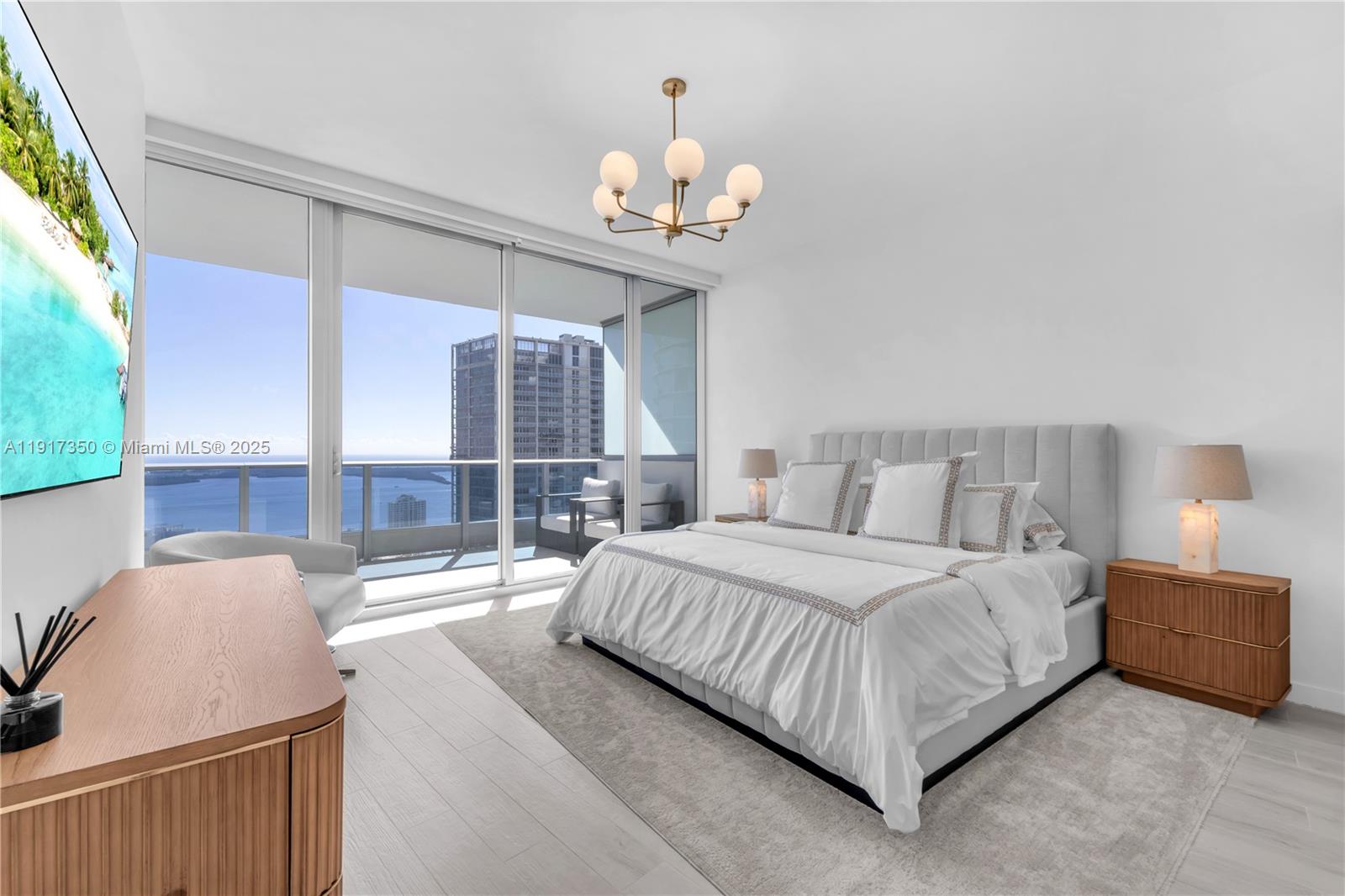 200 Biscayne Blvd Way, Unit 5103 Miami, FL 33131 - Photo 13 of 32 a spacious bedroom with a bed and a chandelier