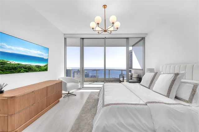 a spacious bedroom with a bed and a chandelier