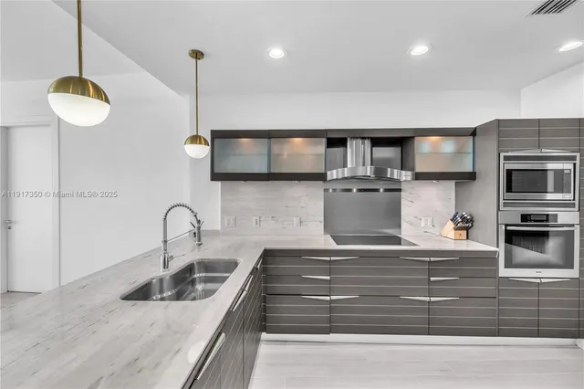 a kitchen with stainless steel appliances granite countertop a sink and a wooden floor