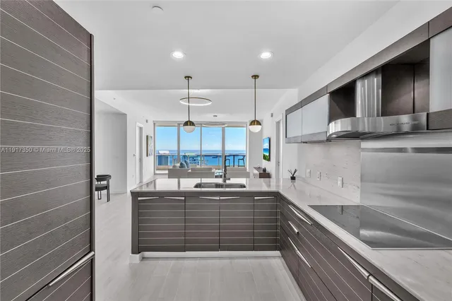 a kitchen with kitchen island cabinets a sink a stove and a refrigerator
