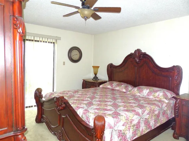 a bed sitting in a bedroom next to a window and a chandelier