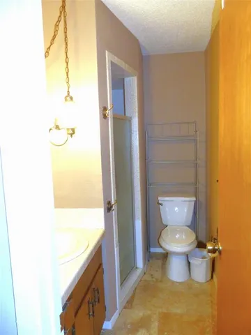 a bathroom with a granite countertop toilet and a sink