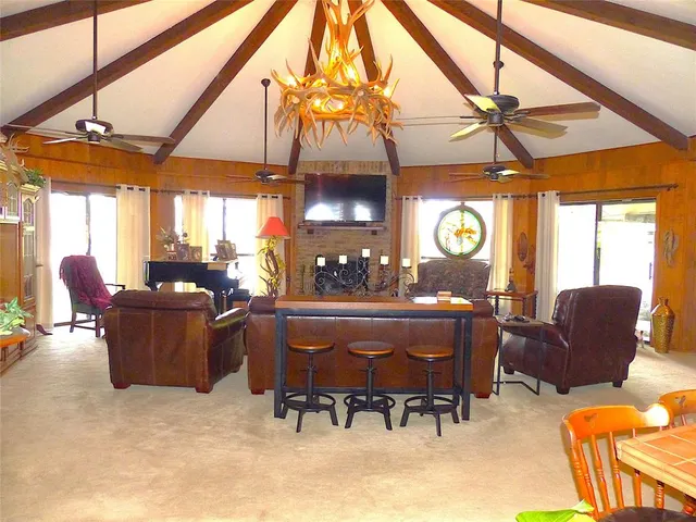 a living room with furniture a chandelier and a floor to ceiling window
