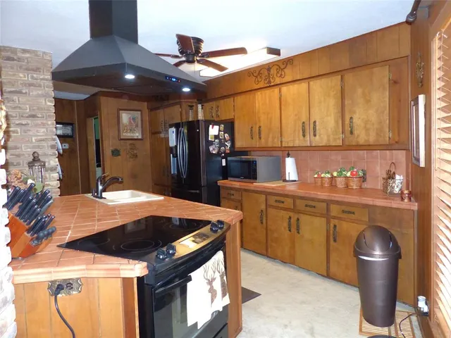 a kitchen with stainless steel appliances kitchen island granite countertop a table chairs in it and wooden floors