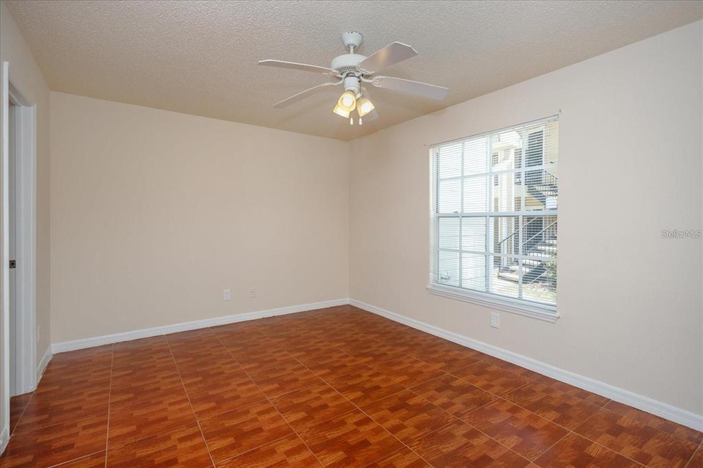 1083 South Hiawassee Road, Unit 617 Orlando, FL 32835 - Photo 6 of 12 an empty room with chandelier fan and windows
