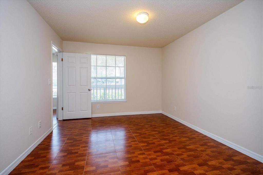 1083 South Hiawassee Road, Unit 617 Orlando, FL 32835 - Photo 8 of 12 an empty room with wooden floor and windows