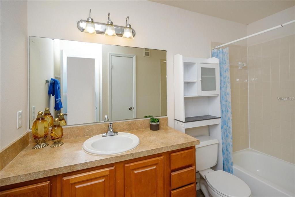 1083 South Hiawassee Road, Unit 617 Orlando, FL 32835 - Photo 9 of 12 a bathroom with a granite countertop sink toilet and shower