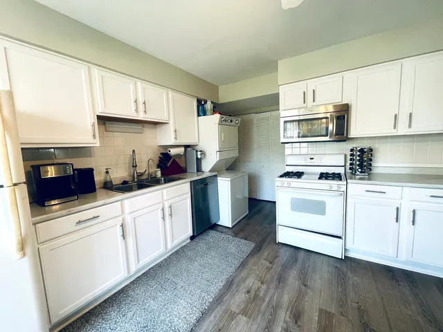 a kitchen with granite countertop white cabinets and white appliances