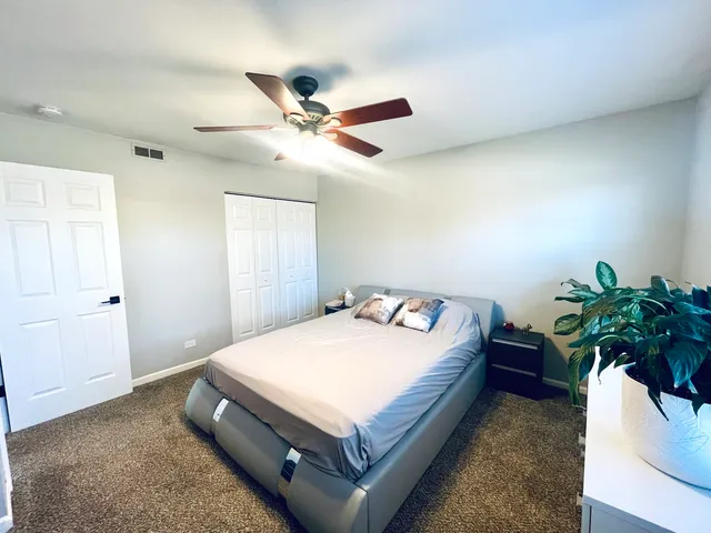 a bedroom with a bed and a potted plant