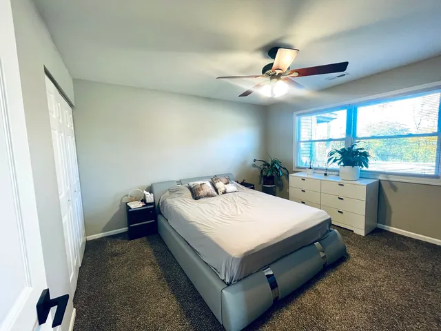 a bed room with a bed and a ceiling fan