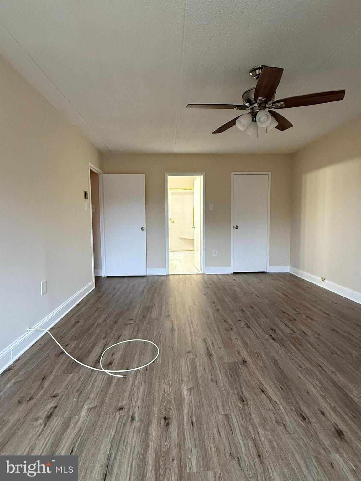 860 Lower Ferry Road, Unit 2K Ewing, NJ 08628 - Photo 12 of 14 an empty room with wooden floor windows and fan