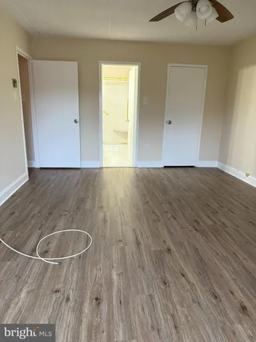an empty room with wooden floor and a sink