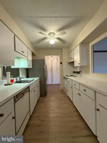 a large kitchen with kitchen island a sink stainless steel appliances and cabinets