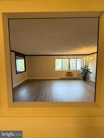 a view of empty room with wooden floor and cabinet