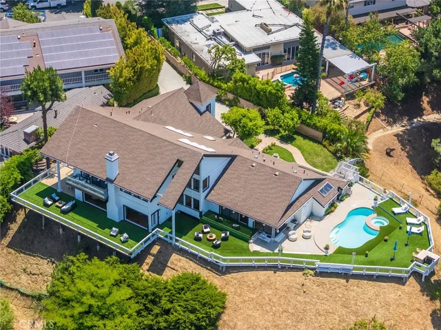 an aerial view of residential house with outdoor space and car parked