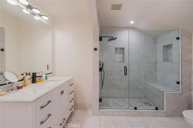 a bathroom with a shower sink and mirror