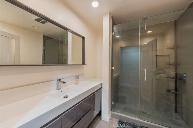 a bathroom with a shower sink and mirror