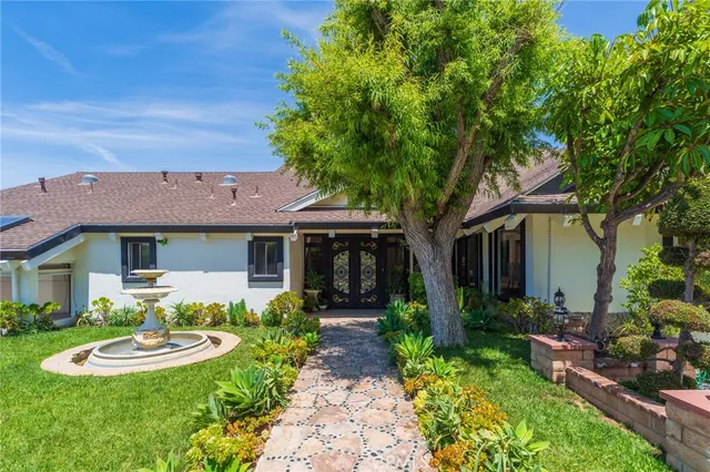 a front view of a house with a garden and plants