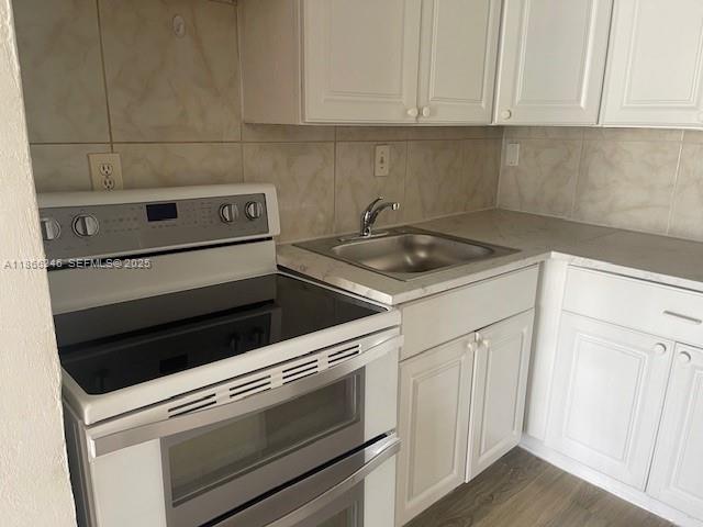 1735 Northeast 164th Street, Unit F204 North Miami Beach, FL 33162 - Photo 13 of 25 a kitchen with granite countertop white cabinets and white appliances