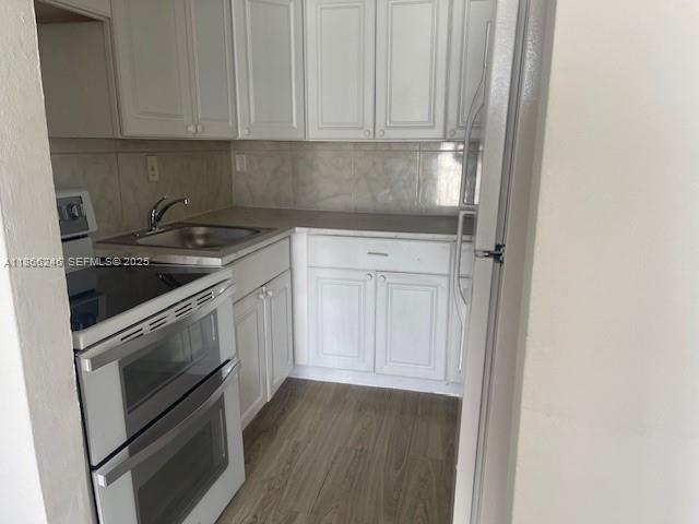 1735 Northeast 164th Street, Unit F204 North Miami Beach, FL 33162 - Photo 15 of 25 a kitchen with granite countertop white cabinets and stainless steel appliances