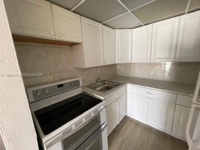 a kitchen with granite countertop white cabinets and white appliances