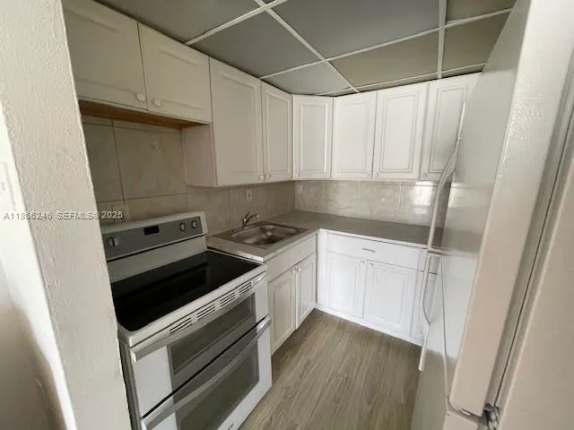 a kitchen with a stove and white cabinets