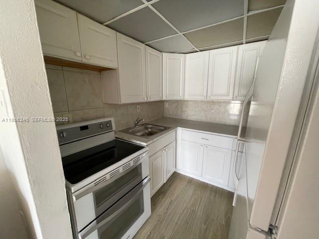 1735 Northeast 164th Street, Unit F204 North Miami Beach, FL 33162 - Photo 17 of 25 a kitchen with a stove and white cabinets
