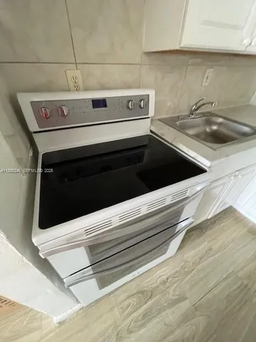a stove top oven sitting inside of a kitchen