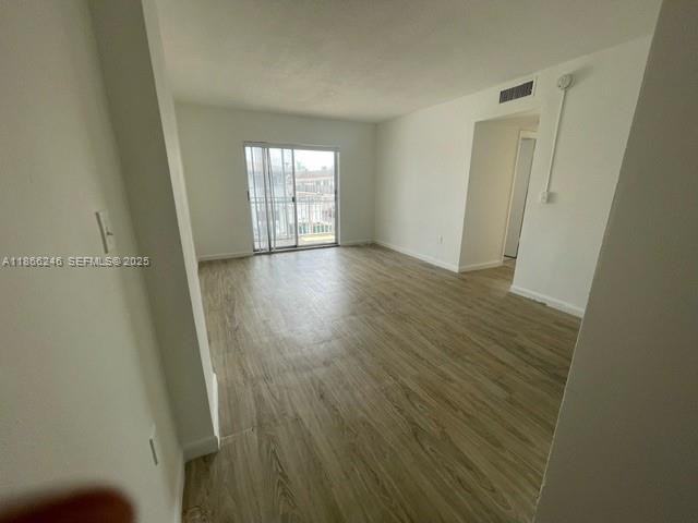 1735 Northeast 164th Street, Unit F204 North Miami Beach, FL 33162 - Photo 3 of 25 an empty room with wooden floor and windows