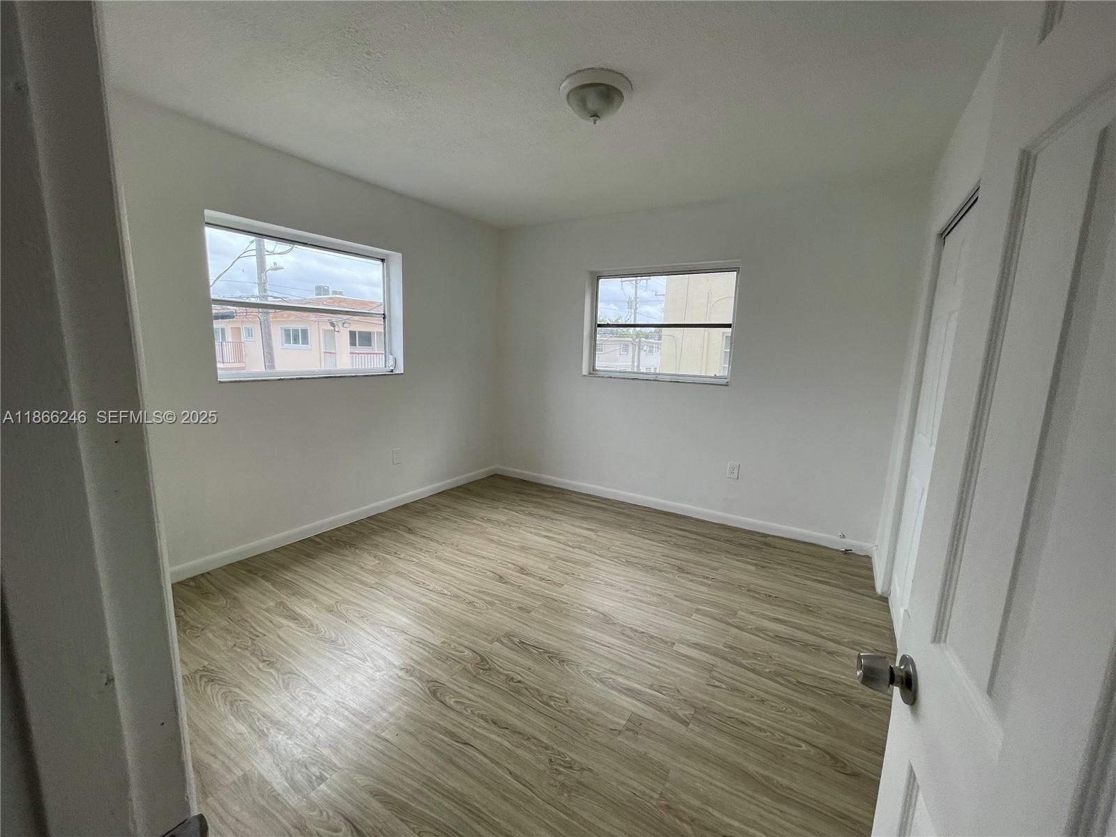 1735 Northeast 164th Street, Unit F204 North Miami Beach, FL 33162 - Photo 10 of 25 an empty room with wooden floor and windows