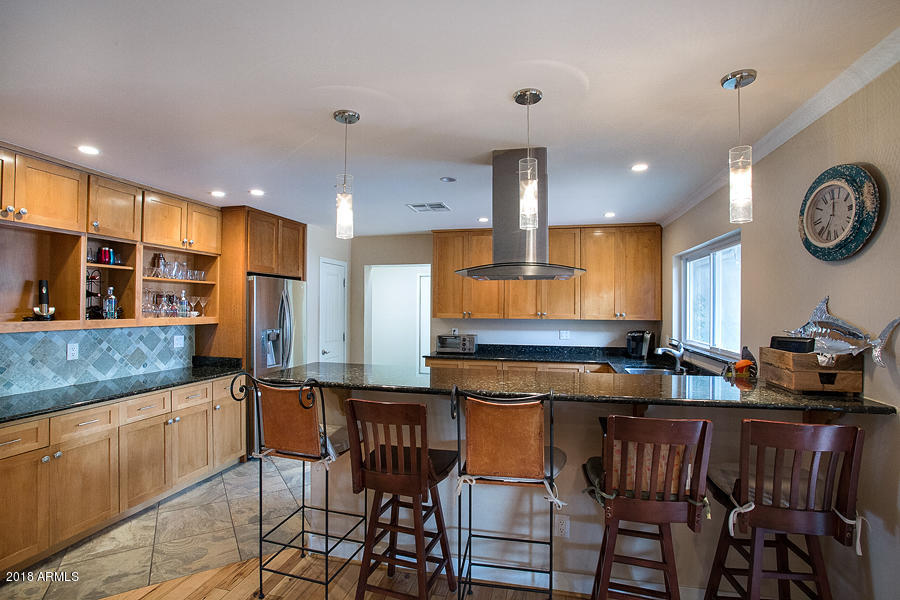 130 East Lawrence Road Phoenix, AZ 85012 - Photo 6 of 18 a kitchen with stainless steel appliances granite countertop a sink a stove a refrigerator cabinets and chairs