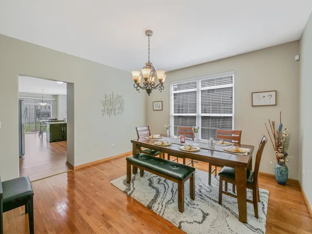 a kitchen with stainless steel appliances granite countertop a refrigerator a sink dishwasher a stove with wooden cabinets and wooden floor