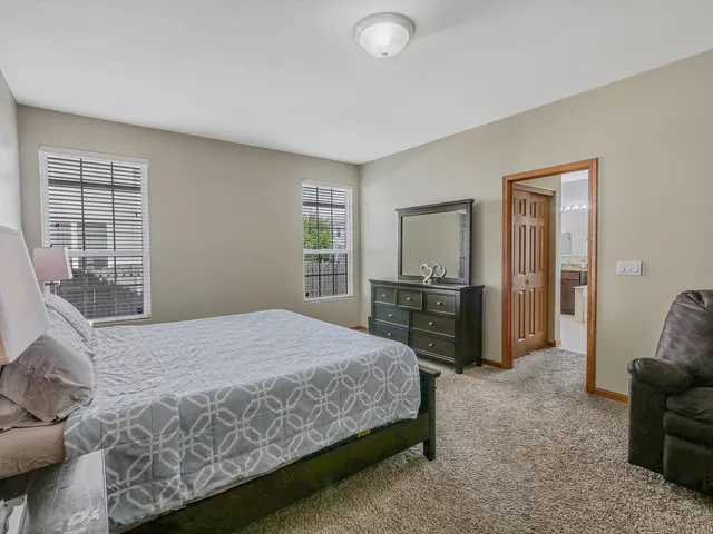 a bedroom with a bed and large windows