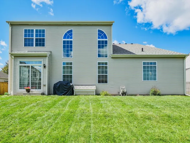 a backyard of a house with plants and wooden fence