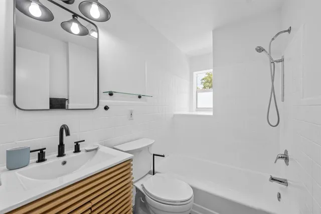 a bathroom with a sink toilet a mirror and shower