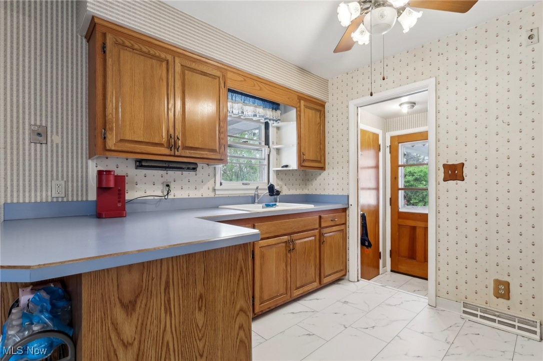 13676 Whitney Road Strongsville, OH 44136 - Photo 9 of 46 Kitchen with visible vents, wallpapered walls, a peninsula, and a sink
