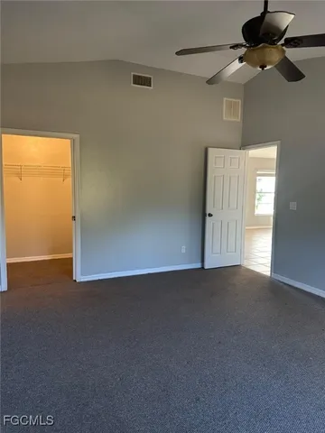 an empty room with windows and fan