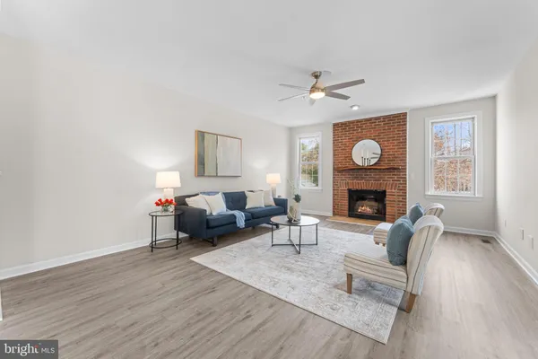 a living room filled with furniture and kitchen view