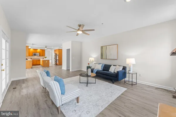 a kitchen with stainless steel appliances a stove a refrigerator and a view of living room