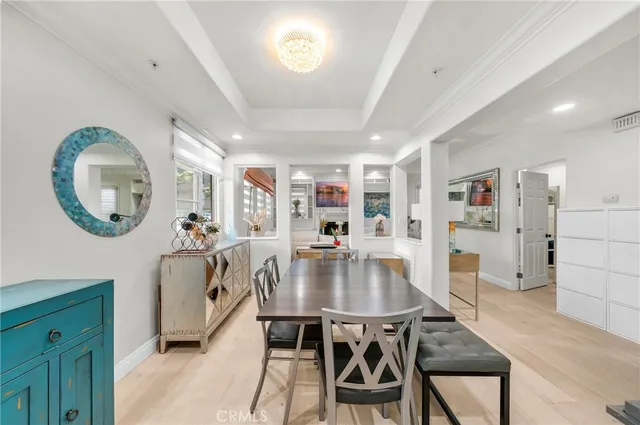 a dining hall with stainless steel appliances kitchen island granite countertop a table and chairs in it