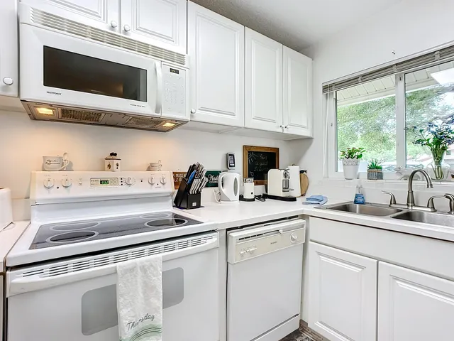 a kitchen with stainless steel appliances white cabinets and a sink