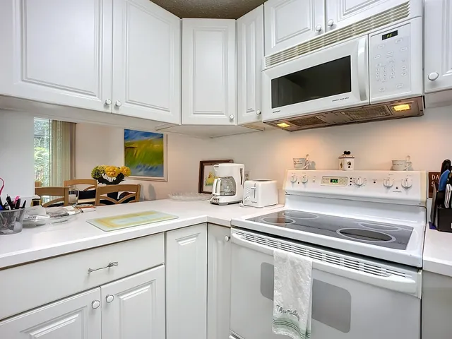 a kitchen with stainless steel appliances granite countertop white cabinets and a stove