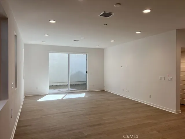 an empty room with wooden floor and mirror