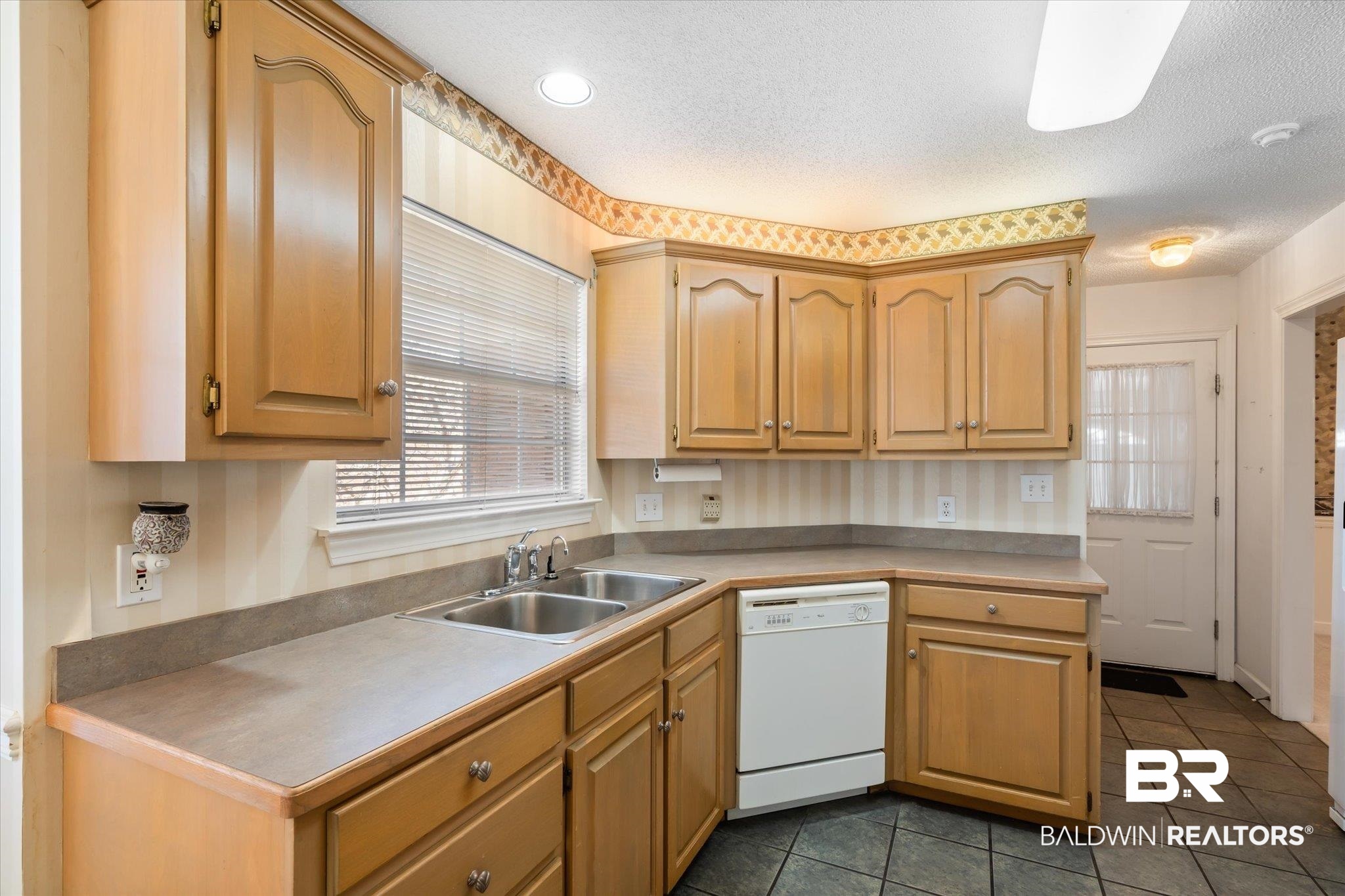2220 Irongate Court Mobile, AL 36695 - Photo 6 of 20 Kitchen featuring a textured ceiling, dark tile patterned flooring, a sink, light countertops, and dishwasher