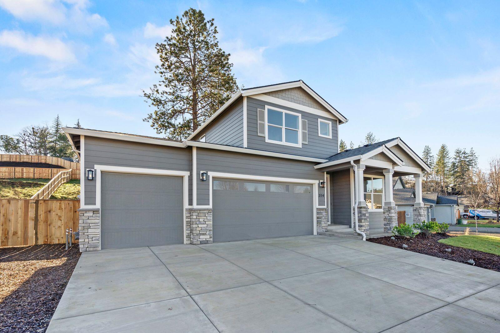 1135 Pumpkin Ridge, Unit 319 Eagle Point, OR 97524 - Photo 3 of 34 a front view of a house with a yard and garage