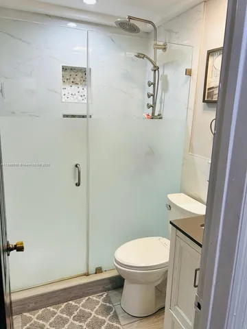 a bathroom with a toilet and a shower