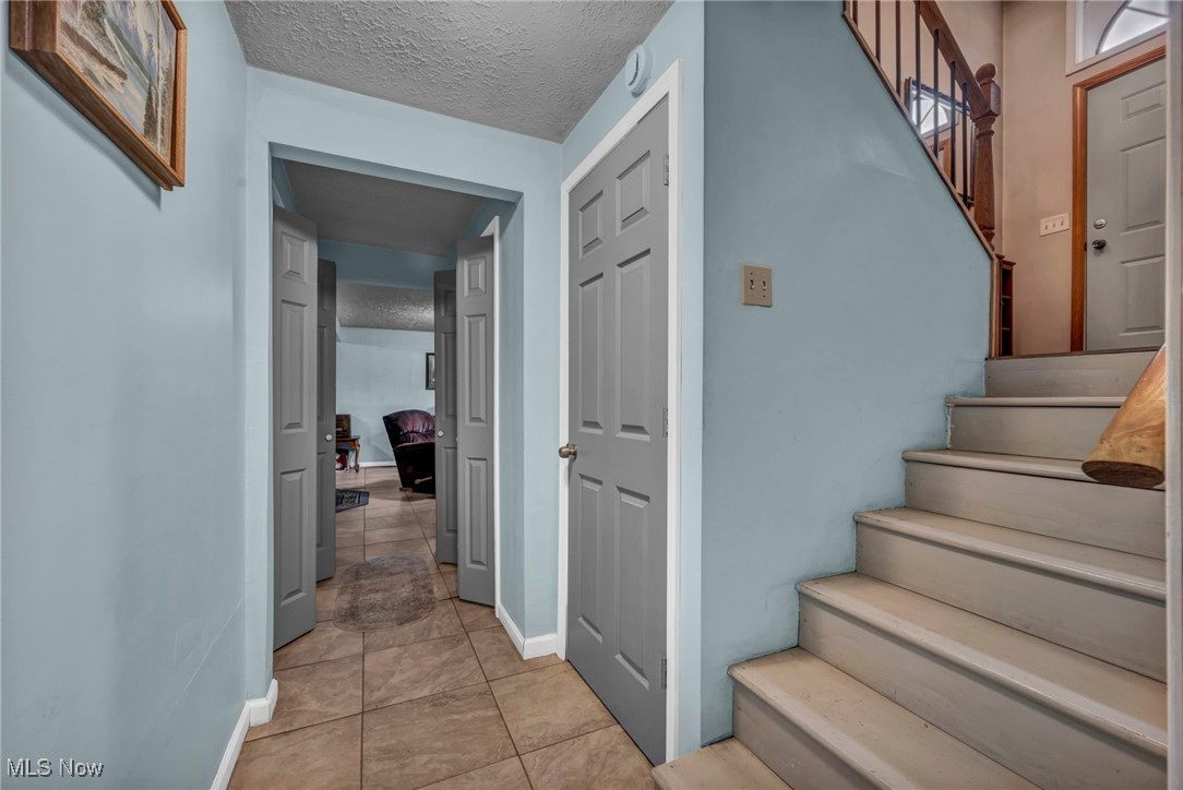 4743 County Line Road Newton Falls, OH 44444 - Photo 24 of 36 Stairs featuring a textured ceiling and tile patterned floors
