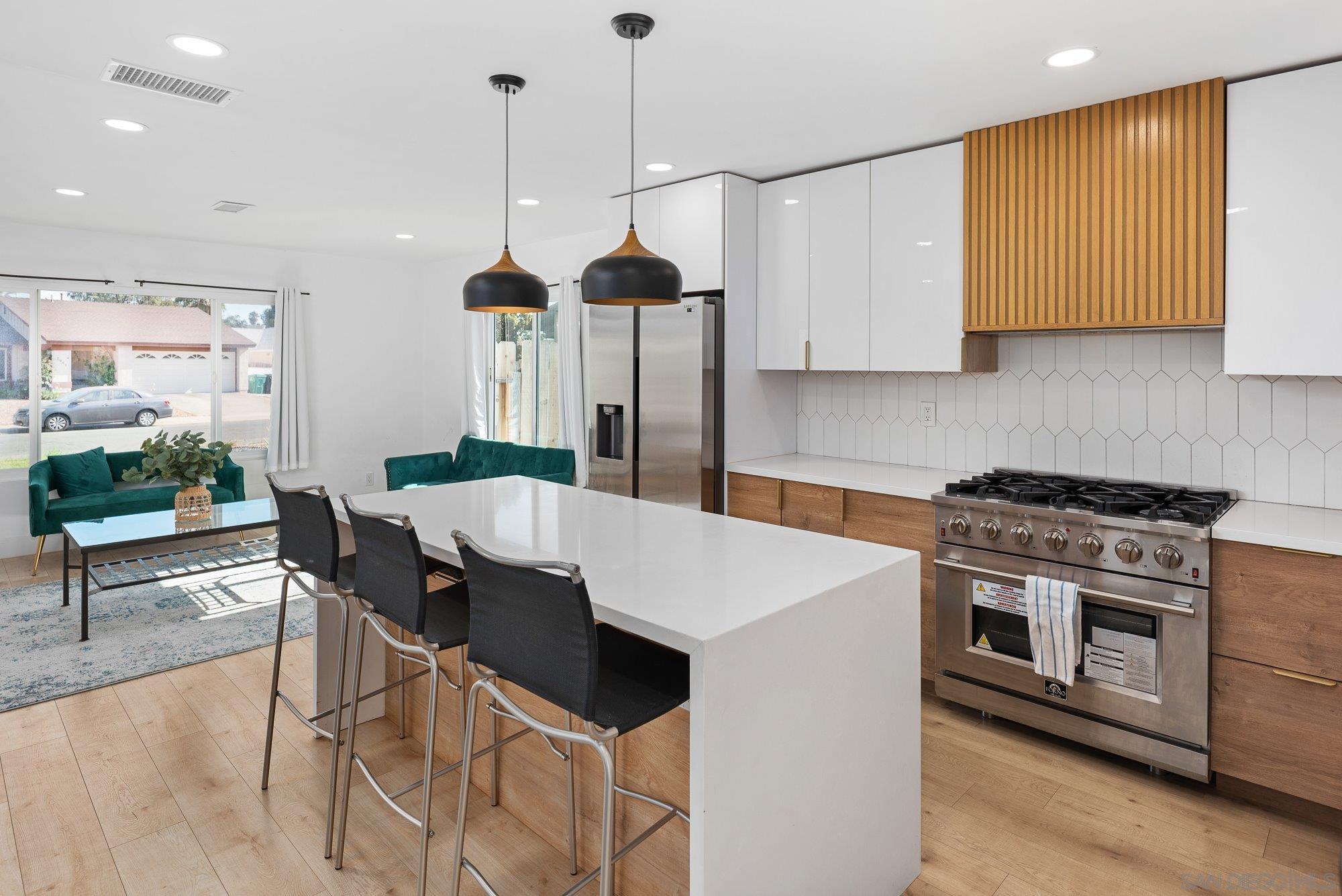 7942 Calico Street San Diego, CA 92126 - Photo 13 of 39 a kitchen that has a stove a table and chairs in it