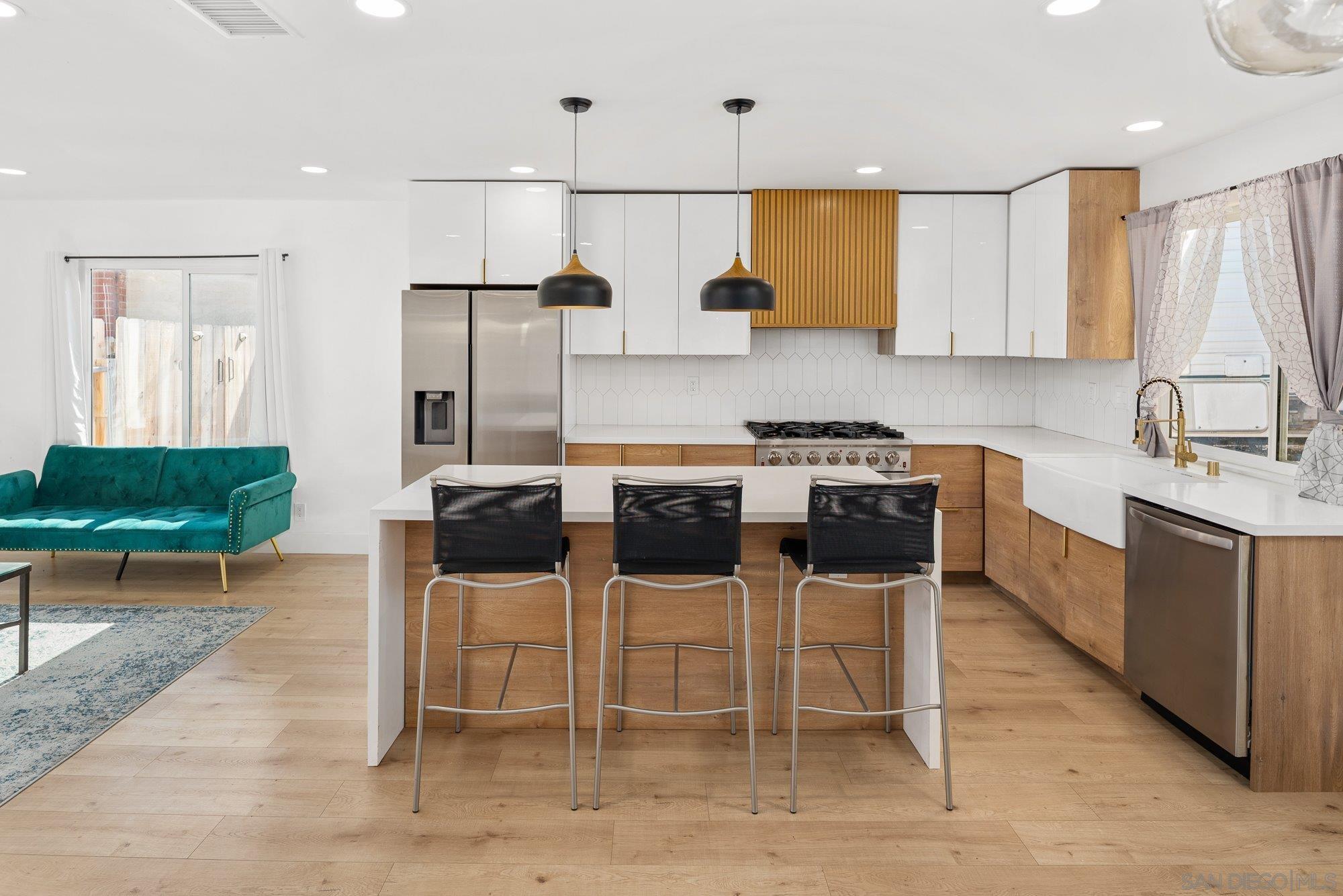 7942 Calico Street San Diego, CA 92126 - Photo 14 of 39 a kitchen with stainless steel appliances kitchen island granite countertop a table and chairs in it