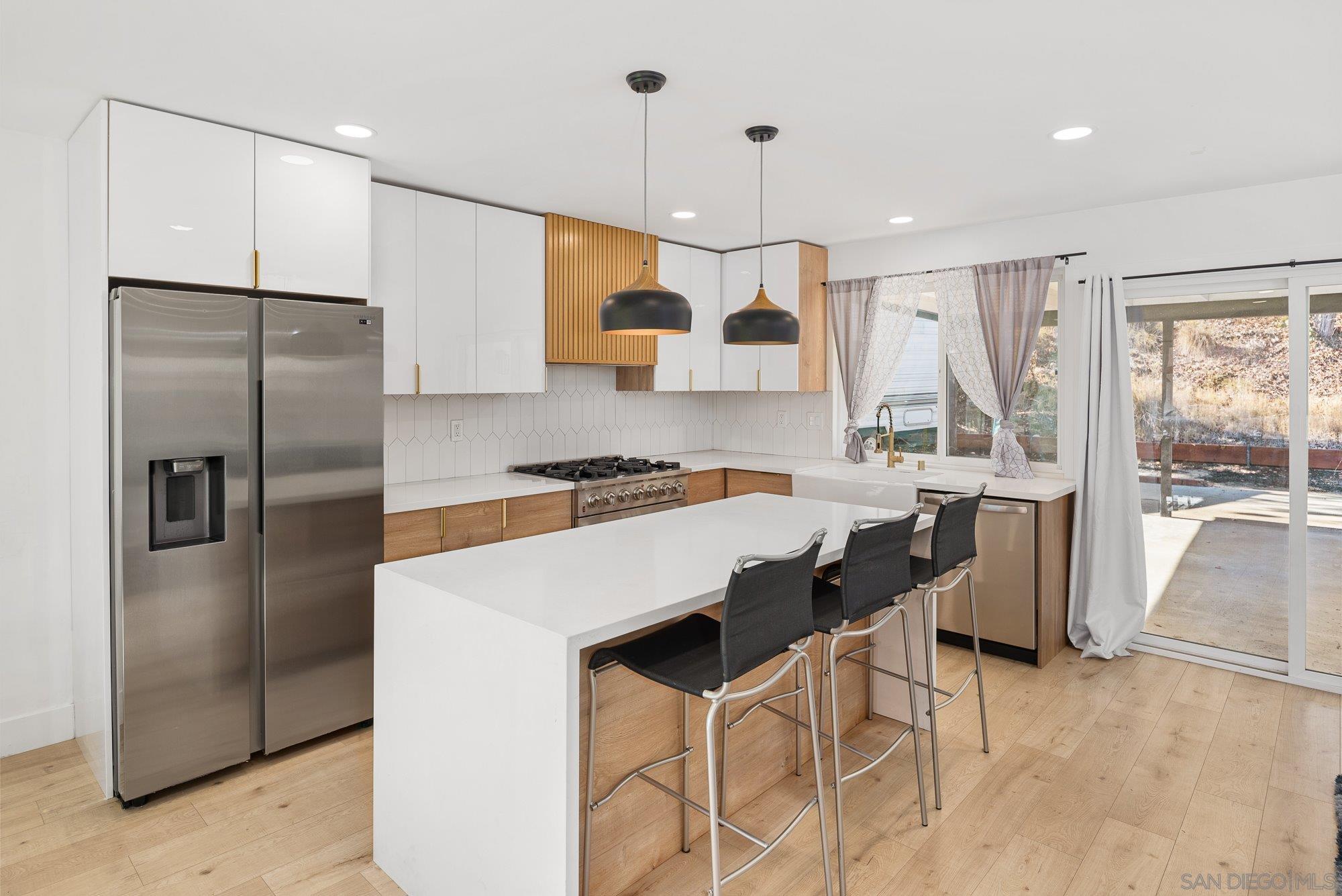 7942 Calico Street San Diego, CA 92126 - Photo 15 of 39 a kitchen with stainless steel appliances granite countertop a refrigerator a sink a stove and a refrigerator